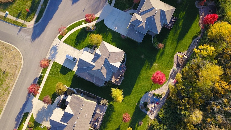 An aerial view of three well maintained homes in a suburban neighborhood.